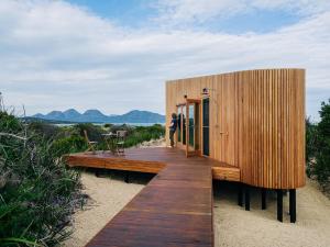 een houten huis op het strand met mensen erop bij Studio Tasmania in Dolphin Sands