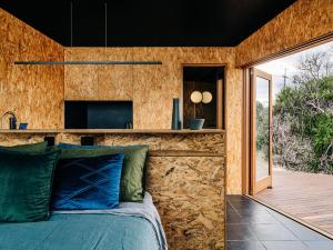 a bedroom with a stone wall and a bed at Studio Tasmania in Dolphin Sands