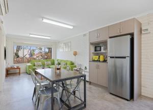 a kitchen and living room with a table and a refrigerator at Dreamy Nature Getaway in Rhyll