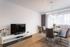 sala de estar con mesa de comedor y TV de pantalla plana en Apart-Invest Apartament Paryski en Szklarska Poręba
