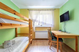 Dormitorio con escritorio, litera y sofá cama en Apart-Invest Apartament Paryski en Szklarska Poręba