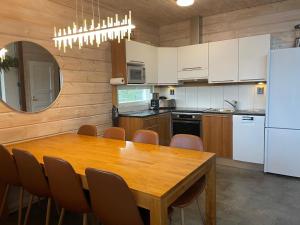 eine Küche mit einem Holztisch und einem weißen Kühlschrank in der Unterkunft Villa Peso2 - 8 henkilölle, HimosYkkösen alue, 70m²+40m² in Jämsä