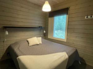 ein Schlafzimmer mit einem Bett und einem Fenster in der Unterkunft Villa Peso2 - 8 henkilölle, HimosYkkösen alue, 70m²+40m² in Jämsä