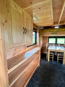 um interior de madeira de uma pequena casa com uma mesa em Beaver Tail Cabin em Hereford