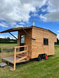 a wooden tiny house sitting in a field at Beaver Tail Cabin in Hereford