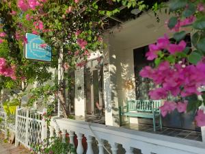 a store front with a bench in a window with pink flowers at Mountains view homestay H2B in Cam Lâm