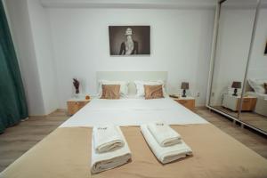ein Schlafzimmer mit einem Bett mit Handtüchern darauf in der Unterkunft Cozy Apartments - One Residence Iasi in Iaşi