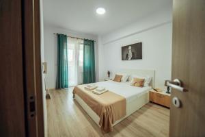 a bedroom with a large bed with green curtains at Tatarasi Apartments - One Residence Iasi in Iaşi
