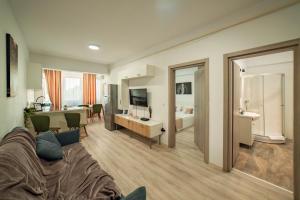 a living room with a couch and a bedroom at Tatarasi Apartments - One Residence Iasi in Iaşi