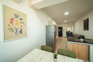 a kitchen and living room with a table and a refrigerator at Tatarasi Apartments - One Residence Iasi in Iaşi