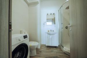 a white bathroom with a toilet and a sink at Tatarasi Apartments - One Residence Iasi in Iaşi +26 photos