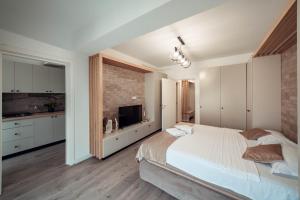 ヤシにあるLUXURY Cozy Apartments and Studios Palas Mall Iasiのレンガの壁、大きなベッド付きのベッドルーム1室