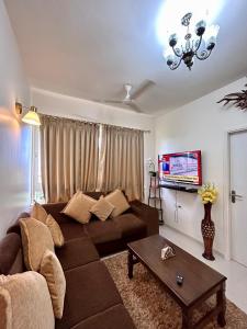un soggiorno con divano marrone e tavolo di Good Stay 1 BHK Apartment 604 a Dabolim