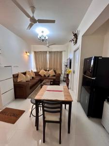 a living room with a table and a couch at Good Stay 1 BHK Apartment 604 in Dabolim