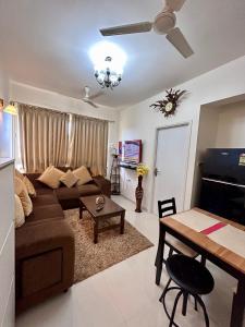 un soggiorno con divano e tavolo di Good Stay 1 BHK Apartment 604 a Dabolim