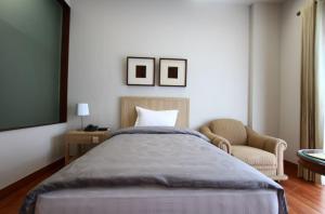 1 dormitorio con 1 cama grande y 1 silla en Via Renata Panglima Polim, en Yakarta