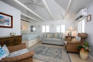 Lillian's Cottage cottage في جزيرة هاربور: غرفة معيشة مع أريكة وسرير