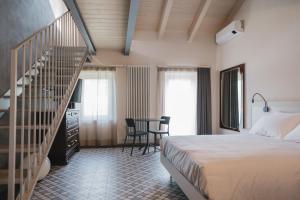 a bedroom with a bed and a spiral staircase at Affittacamere Valèt in San Marzano Oliveto