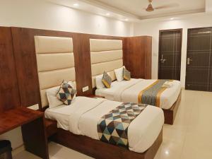 two beds in a hotel room with two beds at Hotel The Tark Near IGI Airport Delhi in New Delhi
