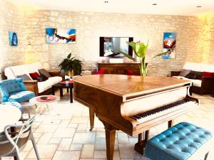 - un salon avec un piano et un canapé dans l'établissement Le Pigeonnier du Perron Hôtel, à Availles en Chatellerault
