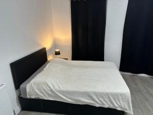 um quarto com uma cama com um cobertor branco em Luxury apartment on Anfield em Liverpool