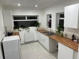 uma cozinha com armários brancos e um balcão de madeira em Luxury apartment on Anfield em Liverpool