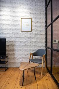 a chair and a table in front of a brick wall at Gallery Hostel Tbilisi in Tbilisi City