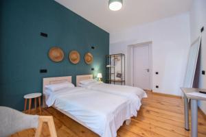 Un dormitorio con una gran cama blanca y una pared azul en Gallery Hostel Tbilisi, en Tiflis
