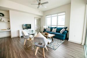 a living room with a blue couch and chairs at 2BR Uptown Furnished Apartment near Truist Fields apts in Charlotte