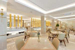 Un comedor con mesas y sillas en un restaurante. en The Beverly Hotel Pattaya, en Pattaya South