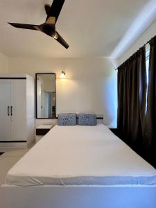 1 dormitorio con 1 cama y ventilador de techo en Good Stay 2 BHK Flat 301 en Dabolim