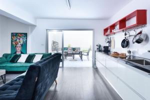 Il comprend un salon avec un canapé vert et une cuisine. dans l'établissement Modern & Chic Apartment w Patio Near Rothschild Blvd by Sea N' Rent, à Tel Aviv