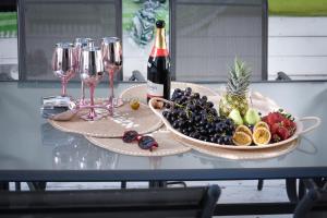 - une table avec une assiette de fruits et des verres à vin dans l'établissement Modern & Chic Apartment w Patio Near Rothschild Blvd by Sea N' Rent, à Tel Aviv