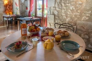 Le Pigeonnier du Perron Hôtel في أفايْ: طاولة خشبية عليها طعام ومشروبات للإفطار