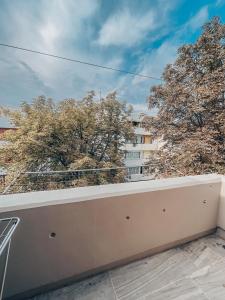 a balcony with trees and a building in the background at THE CHEAPEST IN THE CITY Sagittarius in Komotini