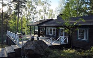 a small cabin with a large rock in front of it at Villa Pellinki in Pellinki