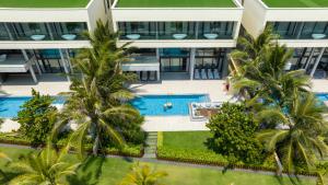 an aerial view of a building with a swimming pool and palm trees at The Five Villas & Resort Quangnam - Danang in Hoi An