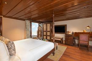 a bedroom with a bed and a desk and a television at Brij Anayra Dharamshala - A Himalayan Luxury Retreat in Dharamshala