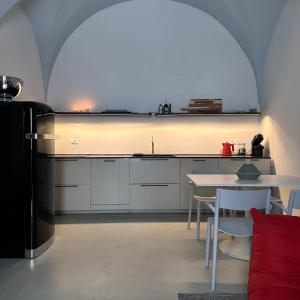 Il comprend une cuisine équipée d'un réfrigérateur et d'une table avec des chaises. dans l'établissement Stanza22, à Ceglie Messapica