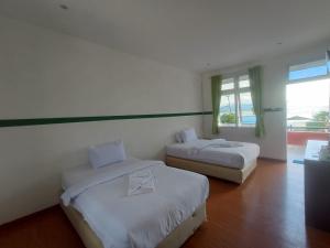 Ένα ή περισσότερα κρεβάτια σε δωμάτιο στο Hotel Ompu Herti
