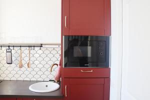 einen roten Schrank mit einer Mikrowelle in der Küche in der Unterkunft Rêves Paisibles Rubis - Choisy in Choisy-le-Roi