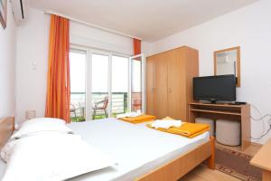 une chambre avec un grand lit et une télévision dans l'établissement Studio Tucepi 5263b, à Tučepi