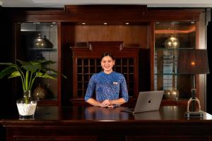 a woman sitting at a desk with a laptop at Paradise Grand Cruise - Lan Ha Bay in Ha Long