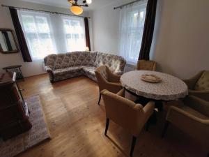 een woonkamer met een bank en een tafel met stoelen bij CHALUPA NAD POTOKEM in Zlaté Hory