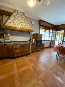 a large kitchen with wooden cabinets and a large window at Casa Chalet, Villa Elisa in Gijón