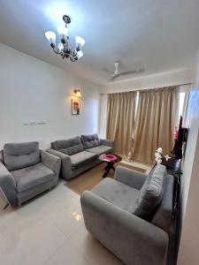 Sala de estar con 2 sofás y TV en Good Stay 2 BHK Premium Apartment 805, en Dabolim