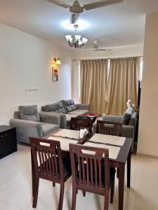 sala de estar con mesa, sillas y sofá en Good Stay 2 BHK Premium Apartment 805, en Dabolim