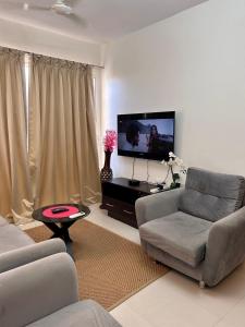 sala de estar con sofá y TV de pantalla plana en Good Stay 2 BHK Premium Apartment 805, en Dabolim