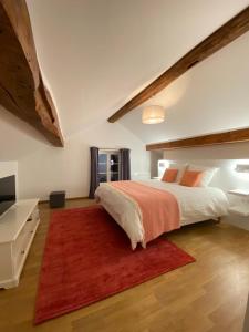 um quarto com uma cama grande e um tapete vermelho em LES DOUVES, charmante dépendance du château em Crèvecoeur-en Brie