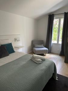 um quarto com uma cama, uma cadeira e uma janela em LES DOUVES, charmante dépendance du château em Crèvecoeur-en Brie